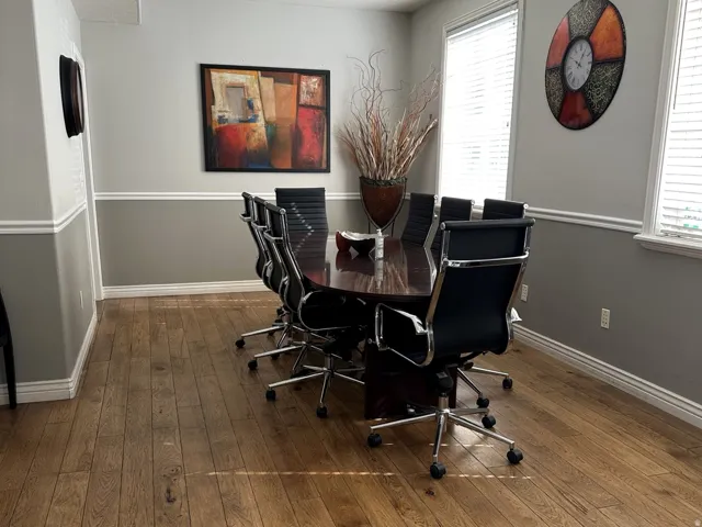 Wood-finish flooring, two-tone wall treatment, white trim, and multiple windows with blinds
