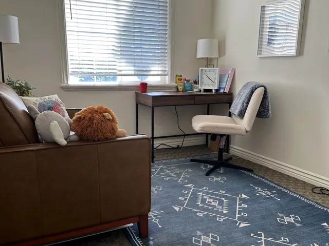Interior space with textured wall finish and window featuring horizontal blinds