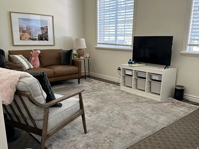 Dual windows with horizontal blinds, wall-to-wall carpeting, and light-toned wall paint