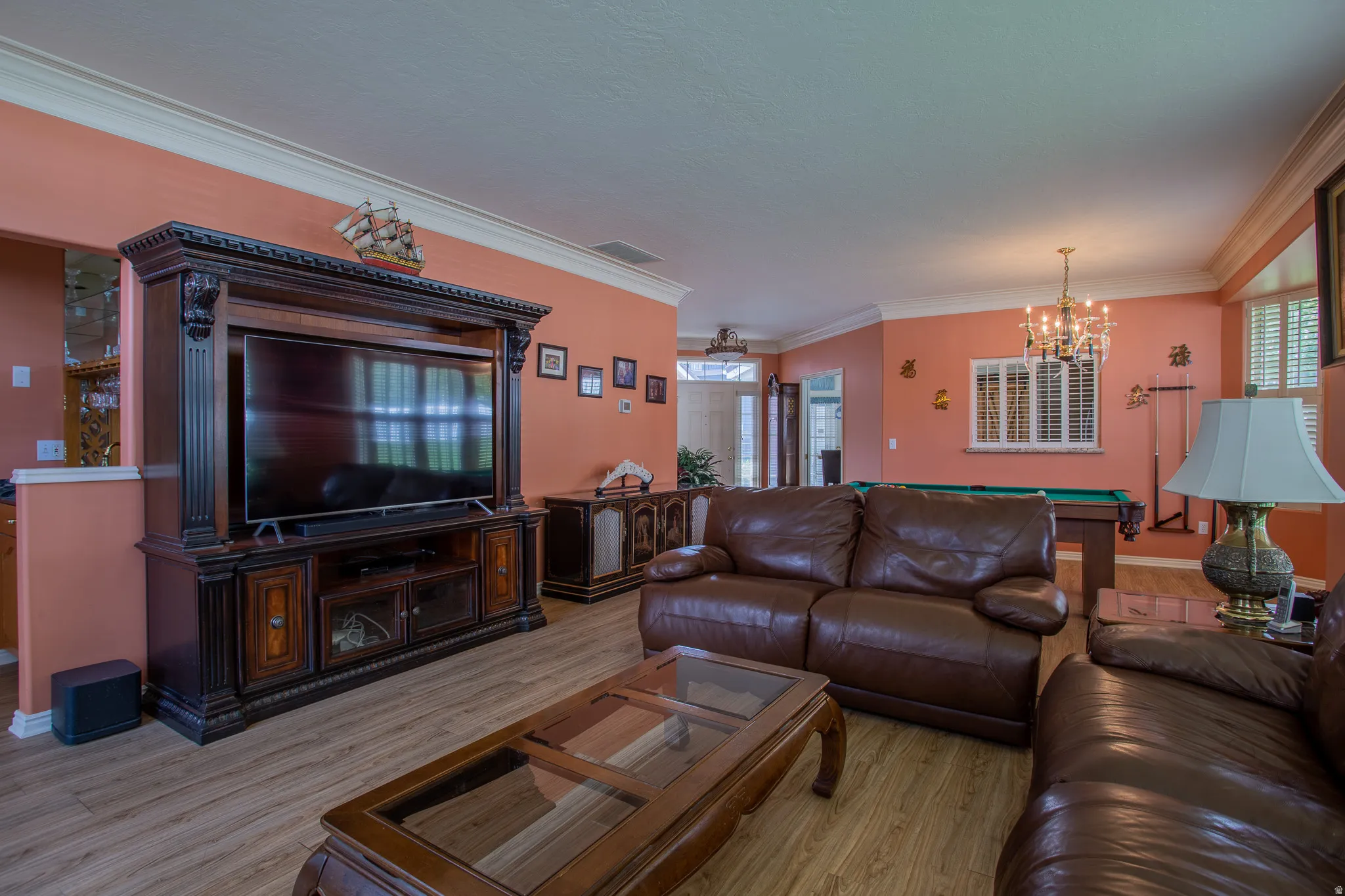 Wood-finish flooring, crown molding, and a built-in entertainment center