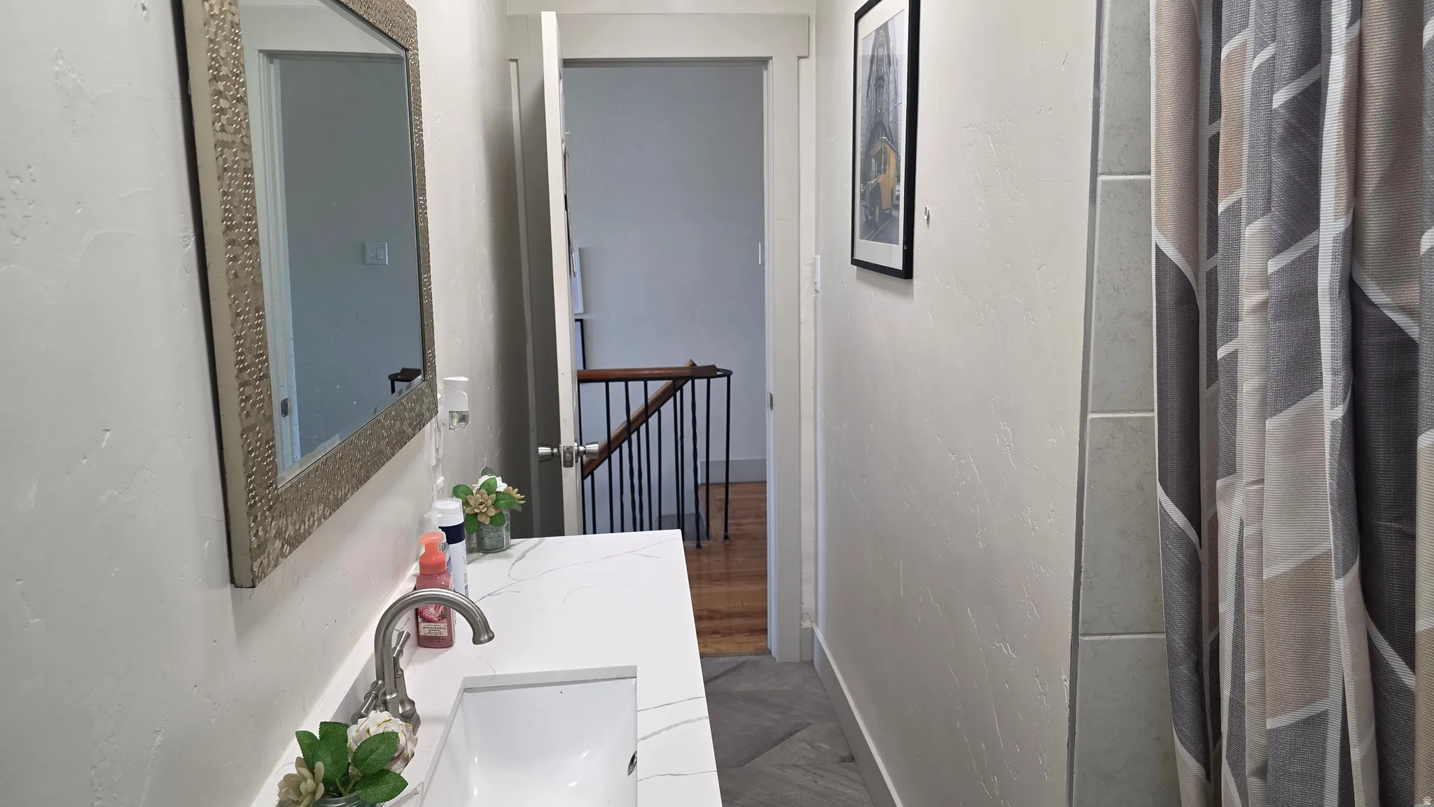 Vanity with a single basin, brushed nickel faucet, and a decorative framed mirror