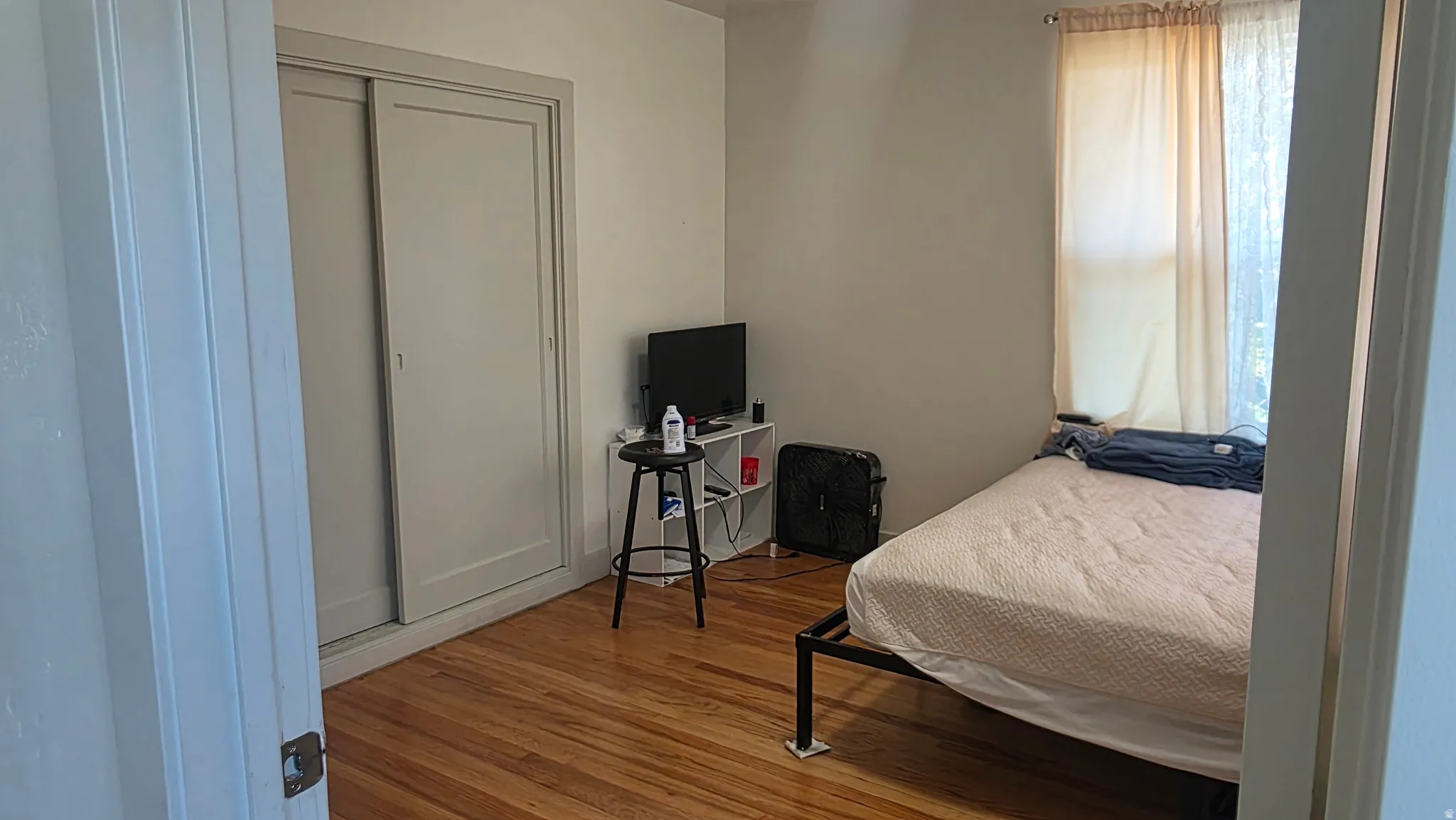 Hardwood flooring, sliding closet doors, and neutral wall paint