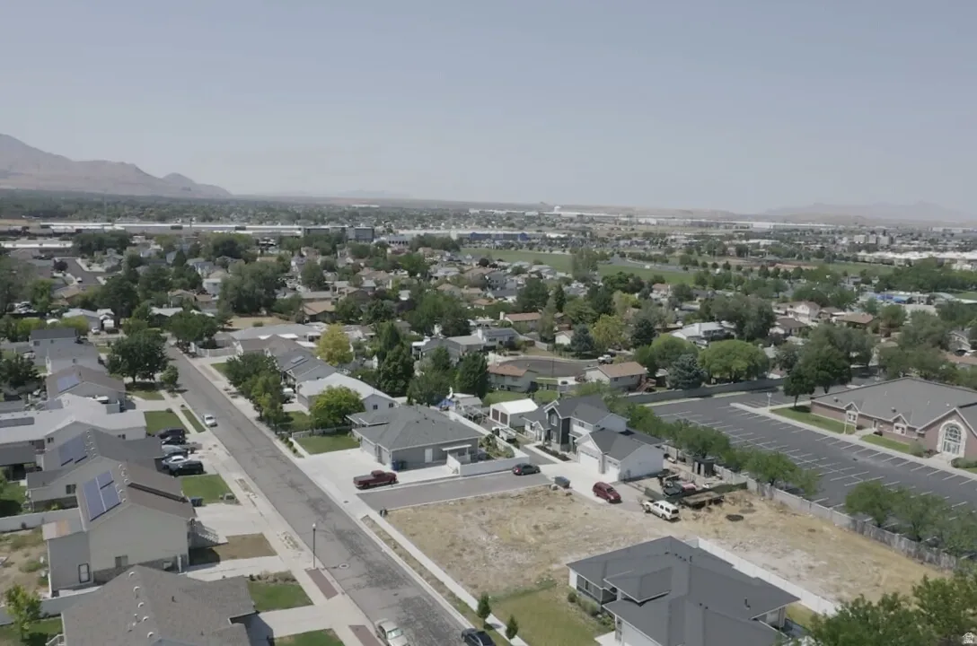 Residential neighborhood with established homes and mature trees, featuring a clear mountain backdrop