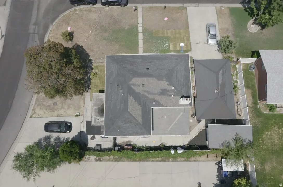 Asphalt shingle roofing, paved driveway, mature trees, and concrete pathways