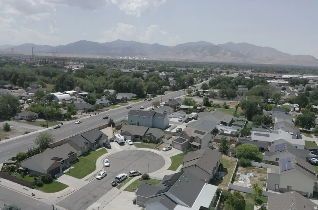 Residential street with cul-de-sac, surrounded by mature trees and distant mountains