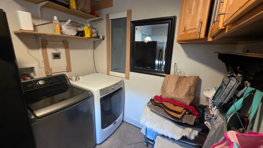 Laundry area with tile flooring and wood-finish cabinetry