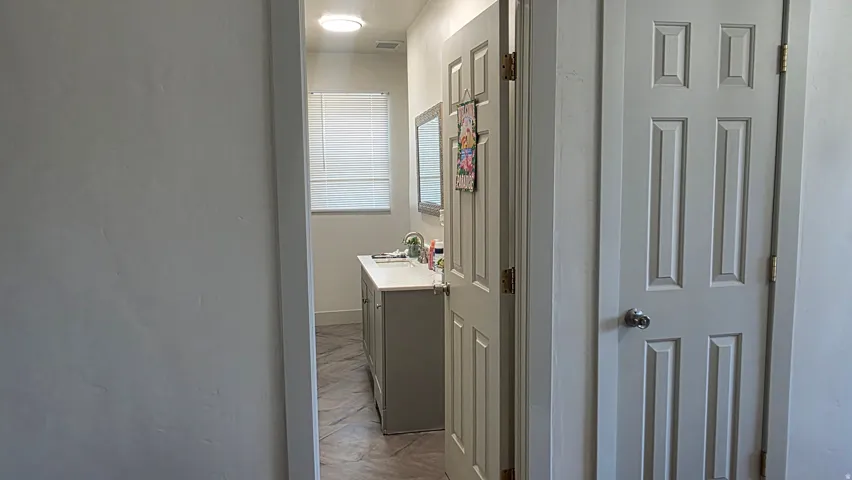 Bathroom featuring a window, vanity with counter, and framed mirror