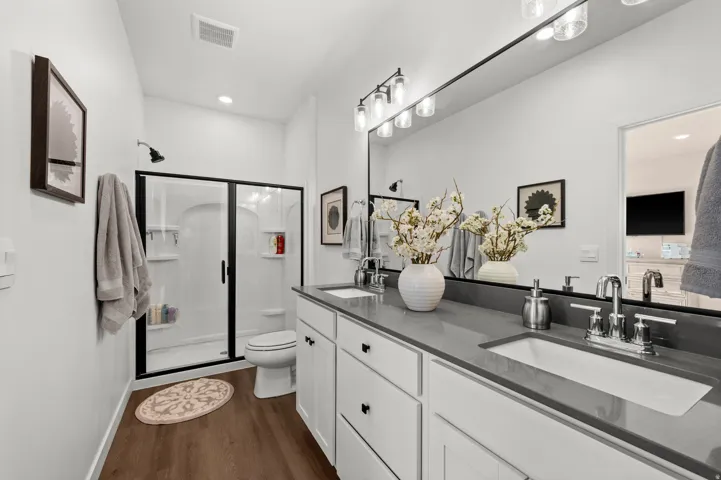 Double vanity with integrated sinks, dark grey countertop, and chrome fixtures