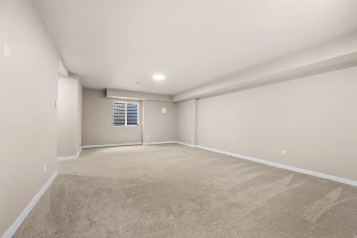 Spacious room featuring neutral carpeting, light-toned walls, and a recessed window