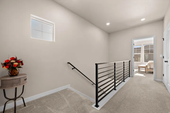 Modern black horizontal bar railing, neutral wall finishes, recessed lighting, and a window with grid detailing