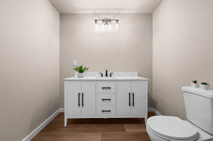 White vanity with a marble-finish countertop, undermount sink, and matte black faucet