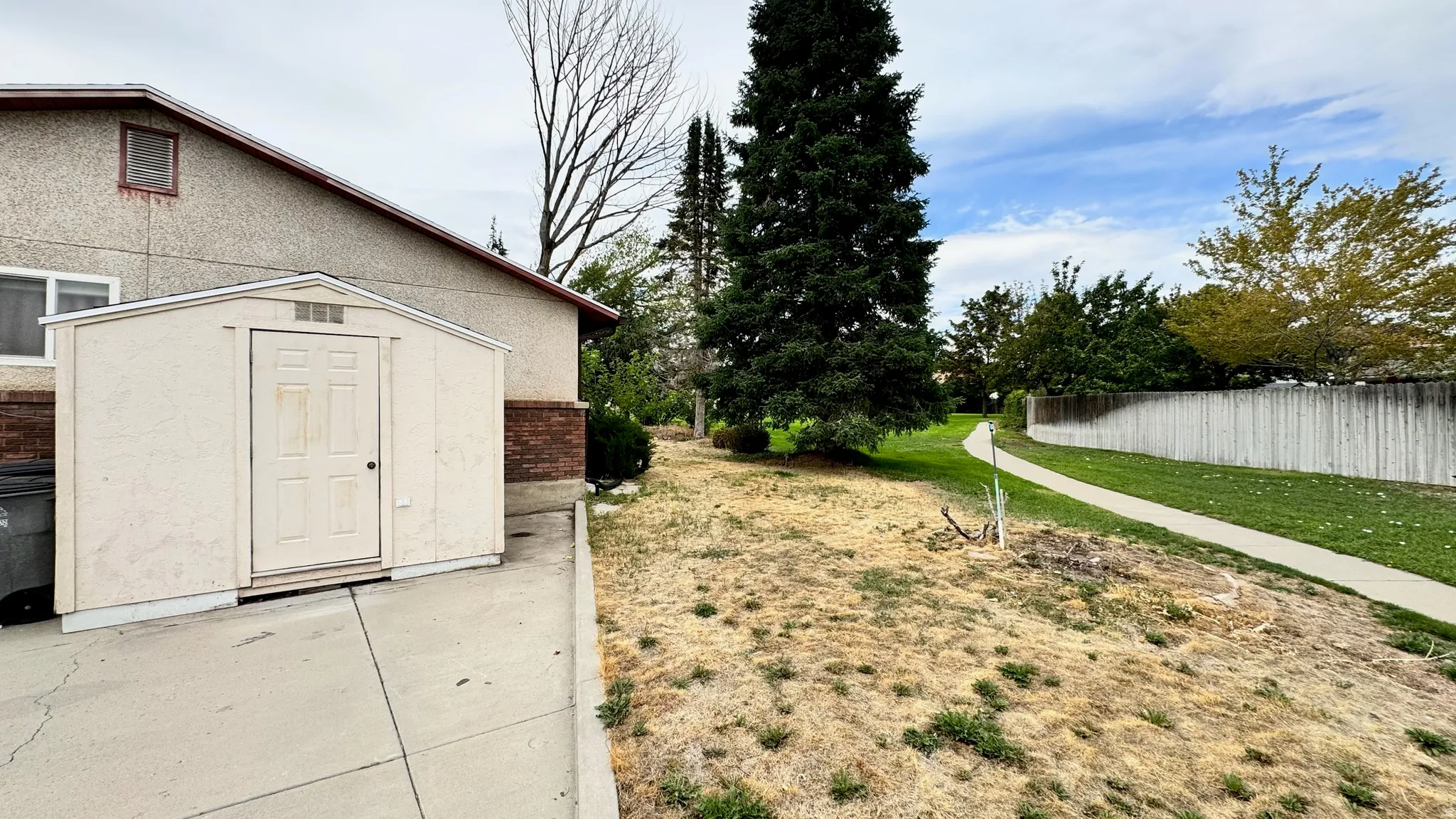 Exterior storage shed with a concrete drive