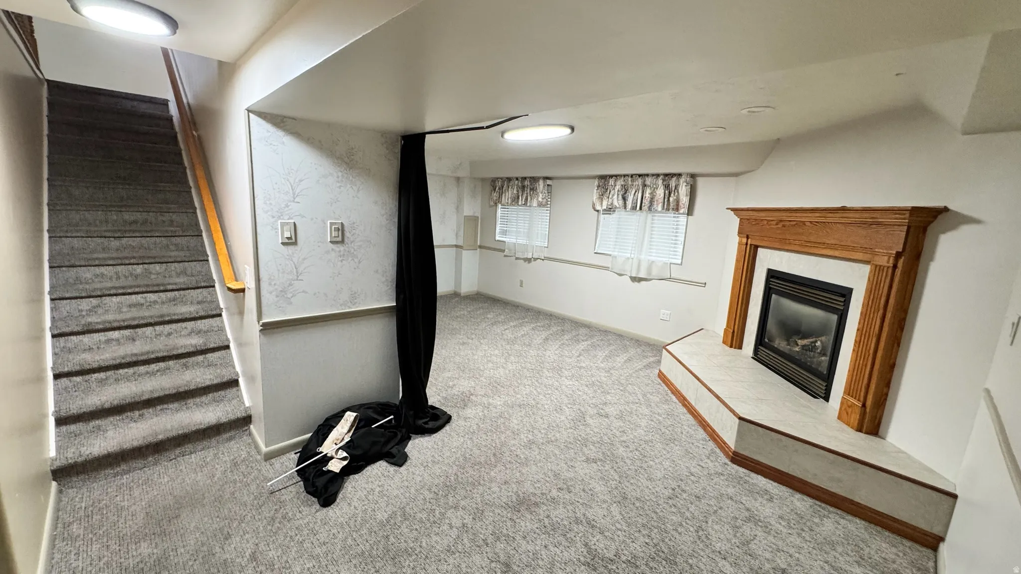 Corner fireplace with wood mantel, built-in gas insert, and tiled hearth