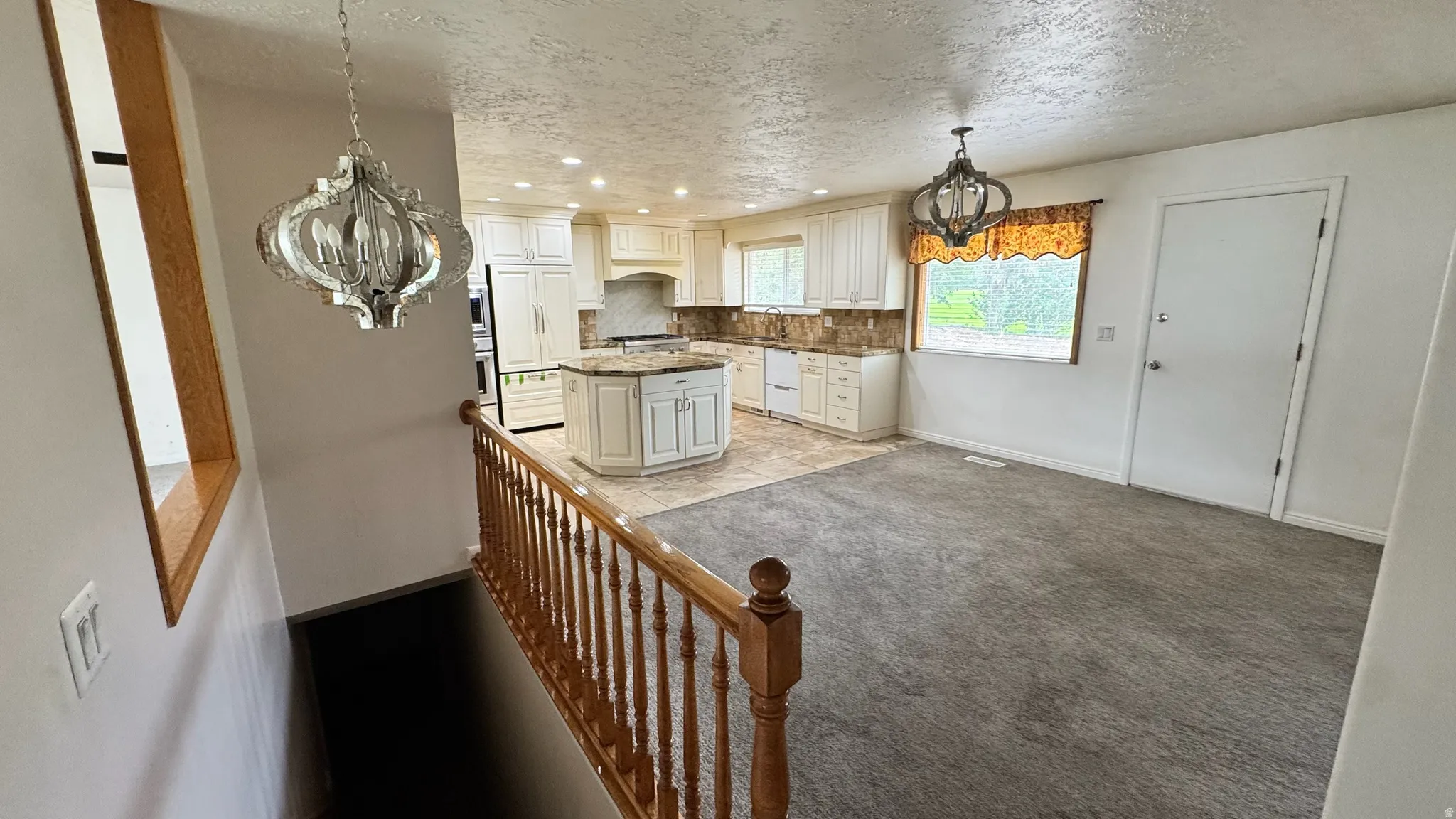 Kitchen featuring white cabinetry, a center island with countertop, and stainless steel appliances