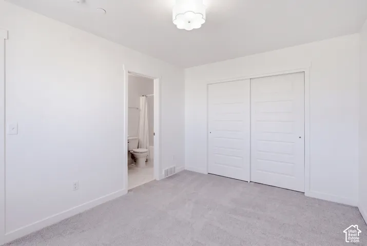 Plush carpeting, crisp white walls, and a contemporary flush-mount light fixture