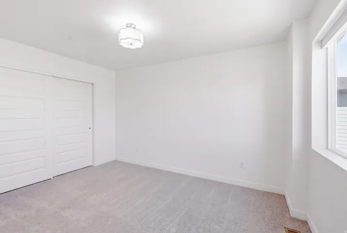 Recessed lighting, light gray carpeting, and white walls
