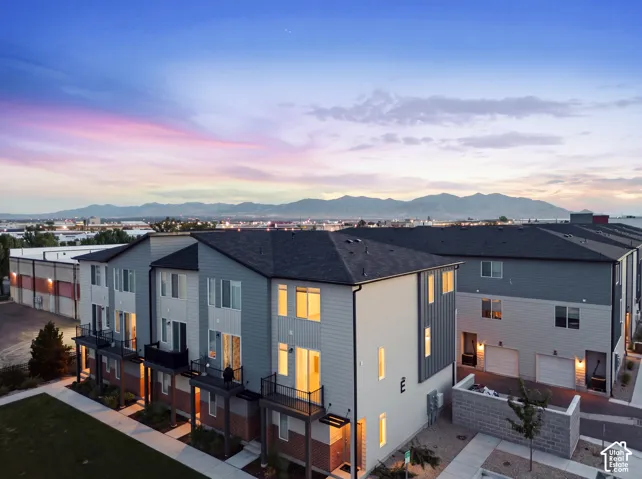 Contemporary townhomes featuring multi-level construction, private balconies, attached garages, and a paved walkway