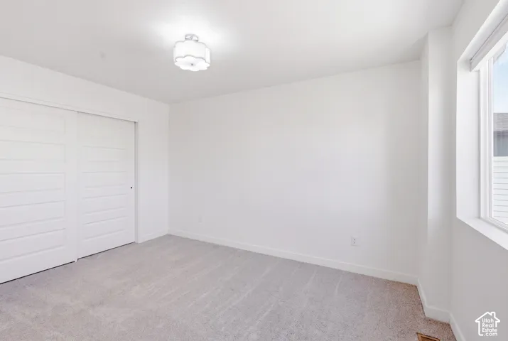 Recessed lighting, light gray carpeting, and white walls