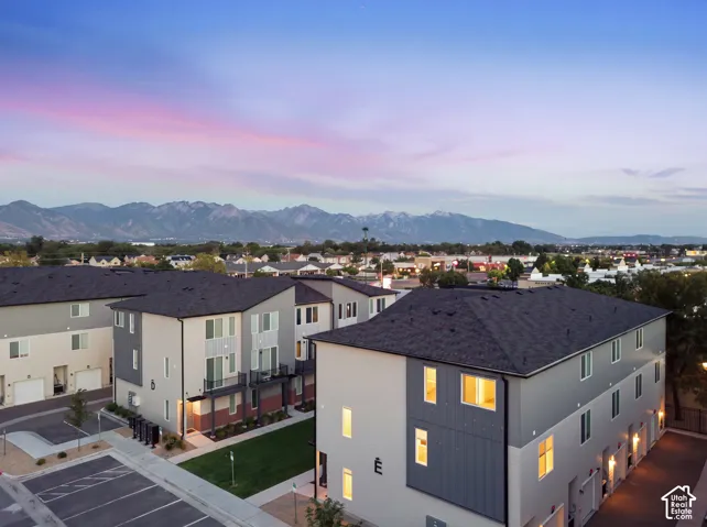 Contemporary multi-story townhomes with dark asphalt shingle roofs and light-toned siding