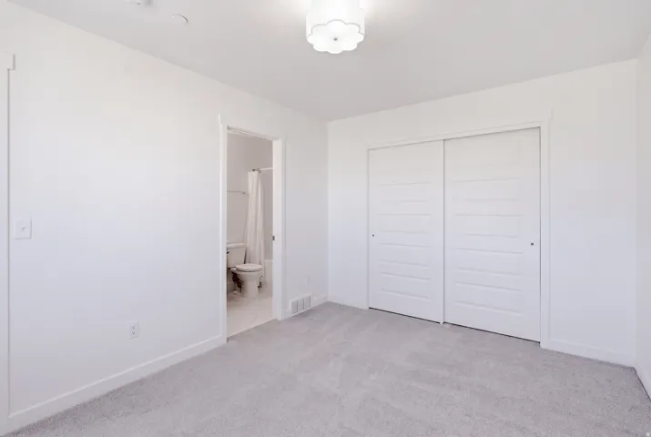 Plush carpeting, crisp white walls, and a contemporary flush-mount light fixture