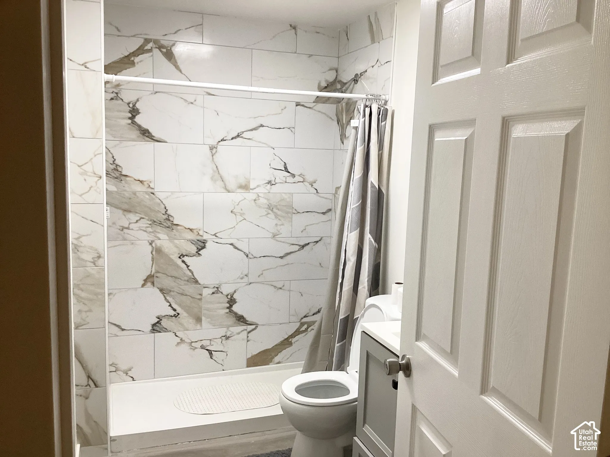 White and gold-veined wall tile in the shower
