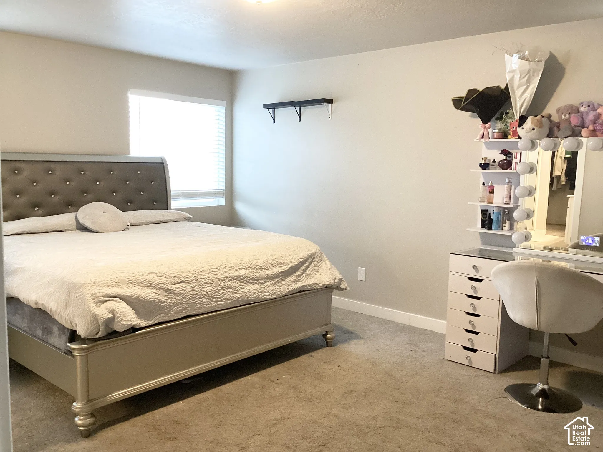 Carpeted bedroom with a window featuring blinds and light-toned walls