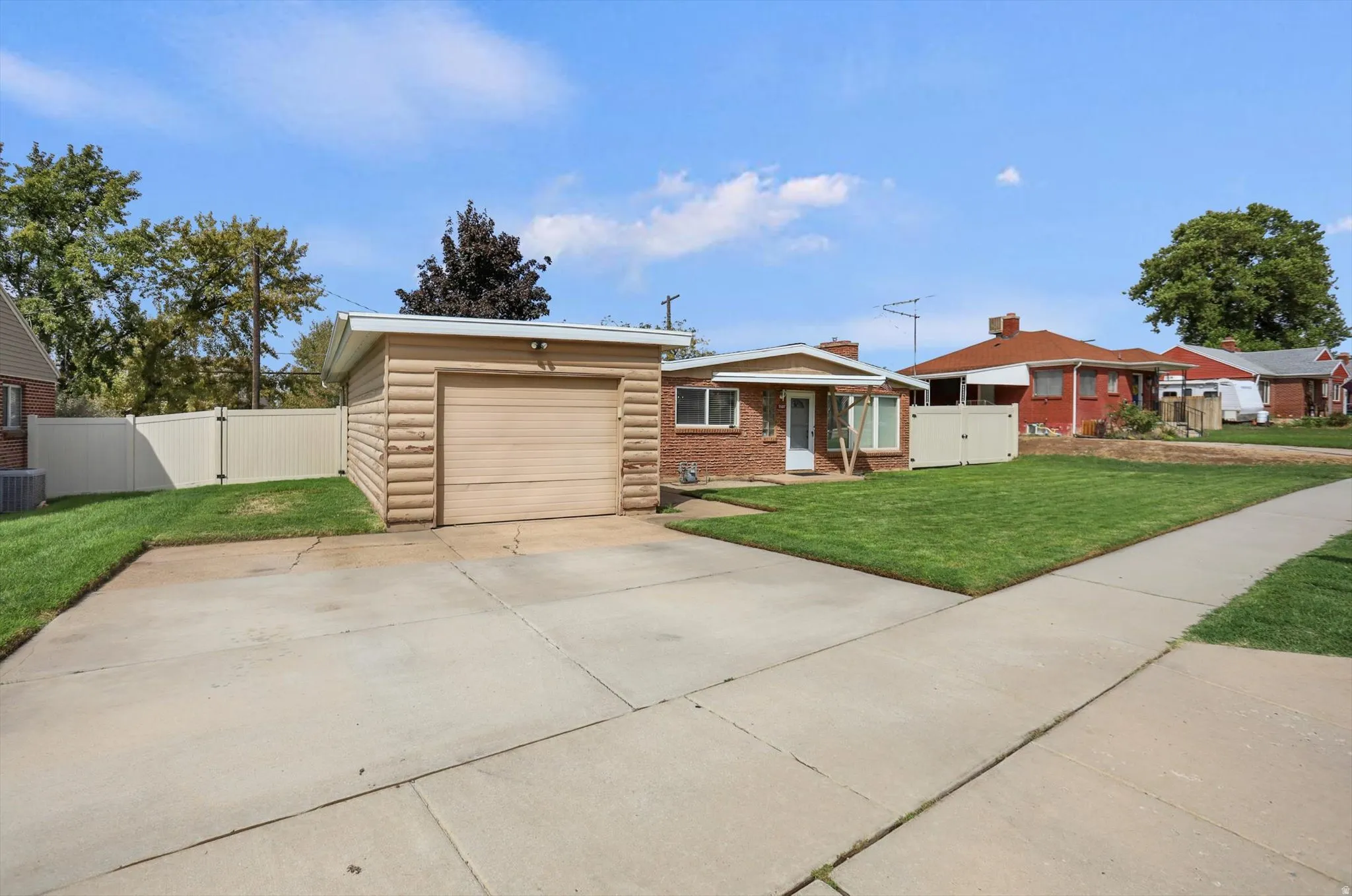 Single-story brick exterior with an attached garage, featuring a concrete driveway and sidewalk