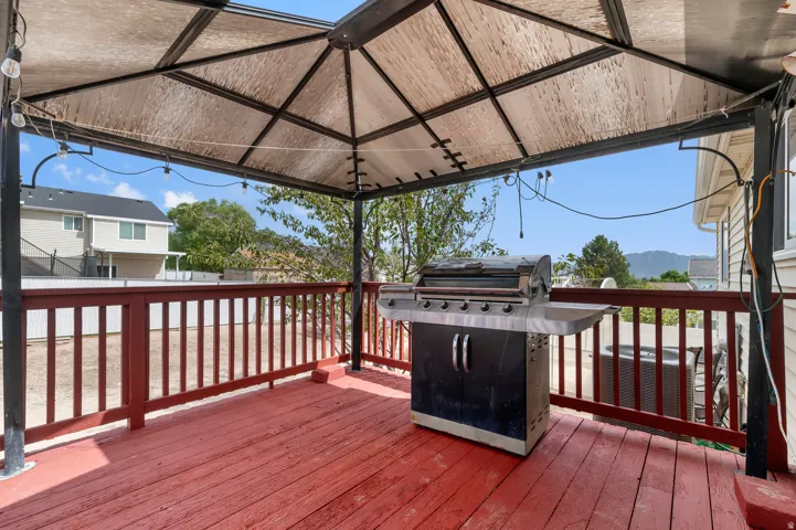 Covered outdoor deck with red-stained wood flooring and coordinating railings