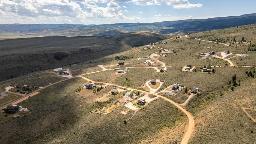 Expansive rural landscape with established residential properties and unpaved roads