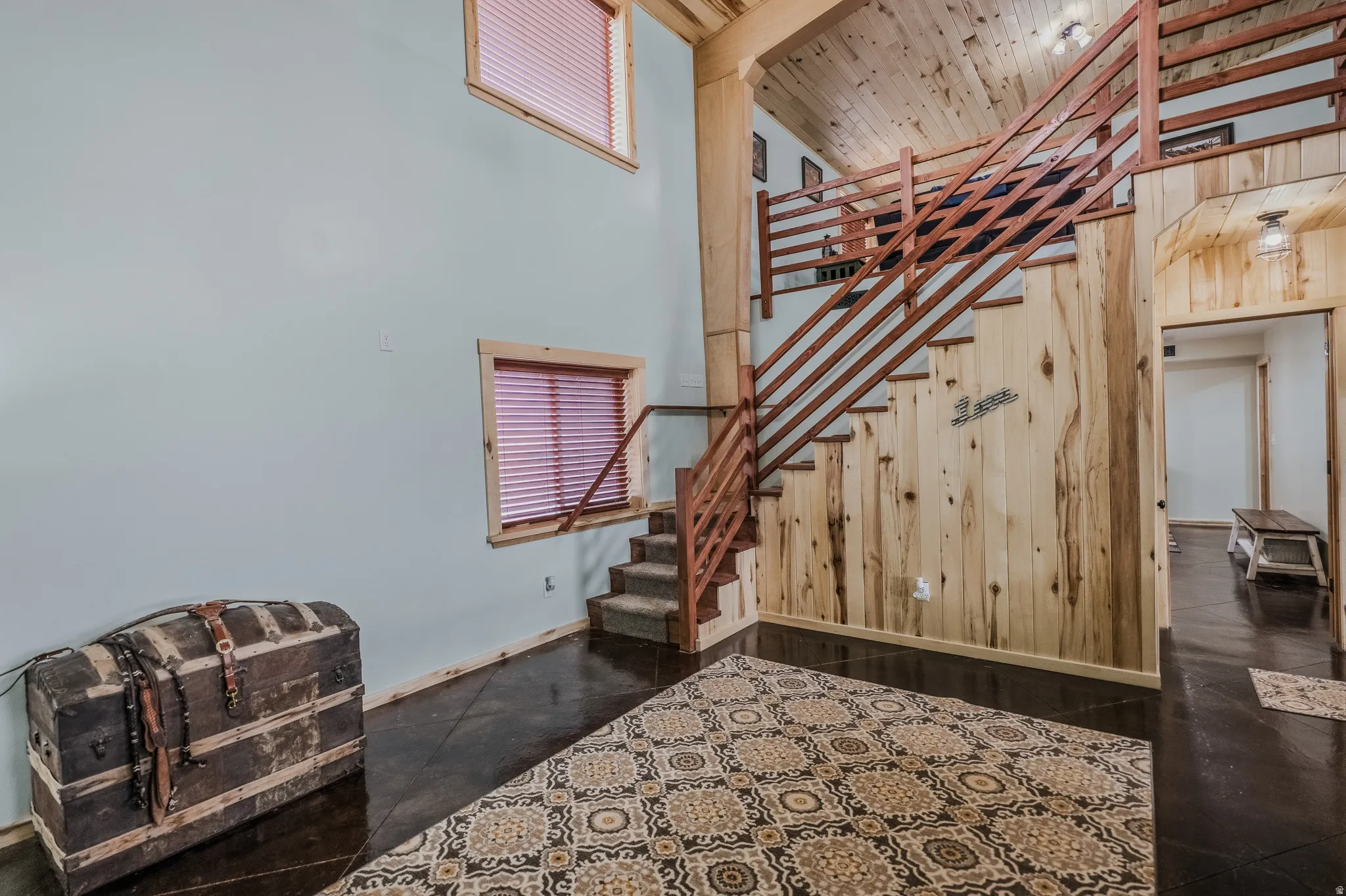 Two-story interior with wood-paneled walls and a matching wood staircase