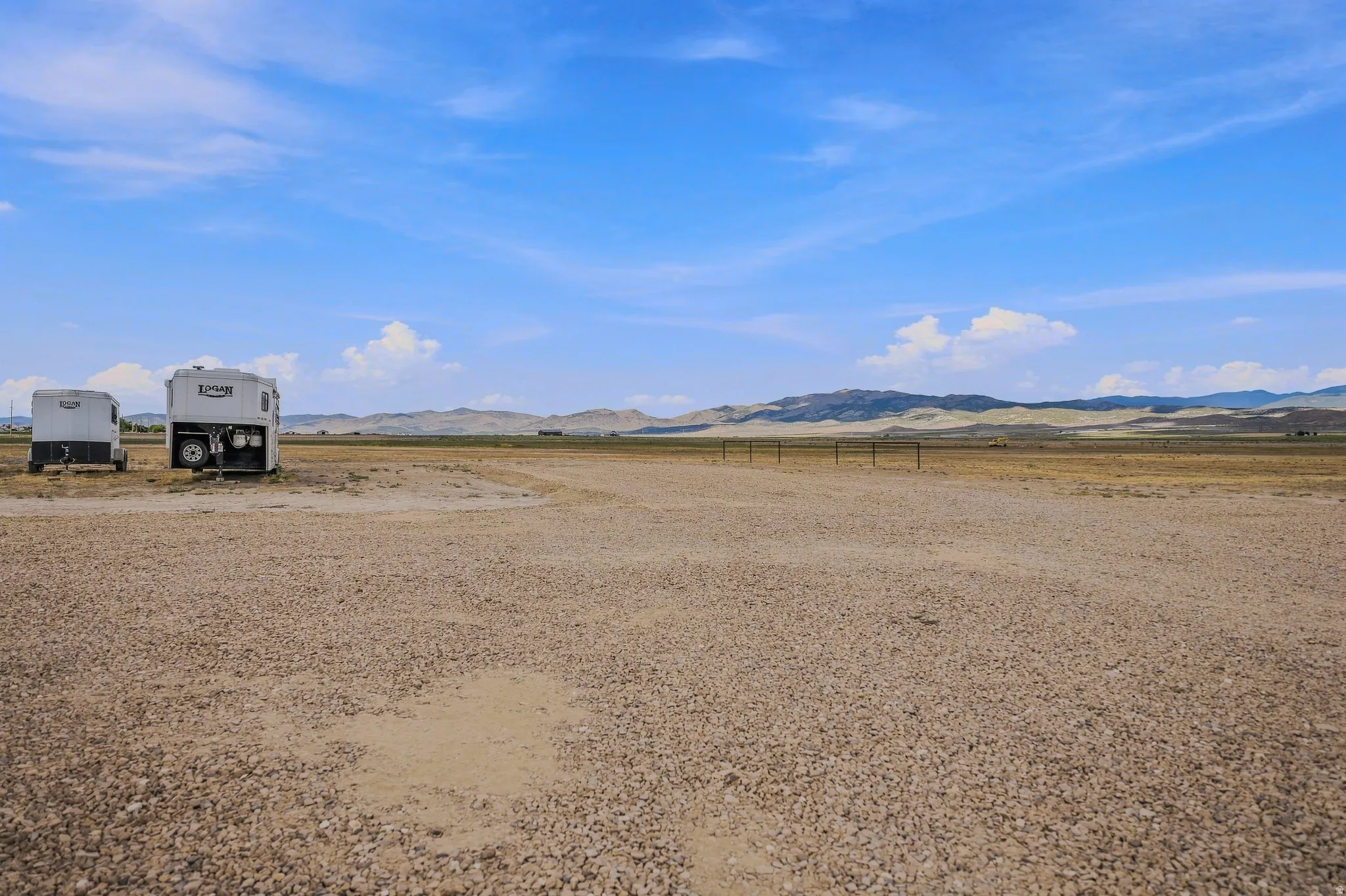 Expansive gravel lot with distant mountains