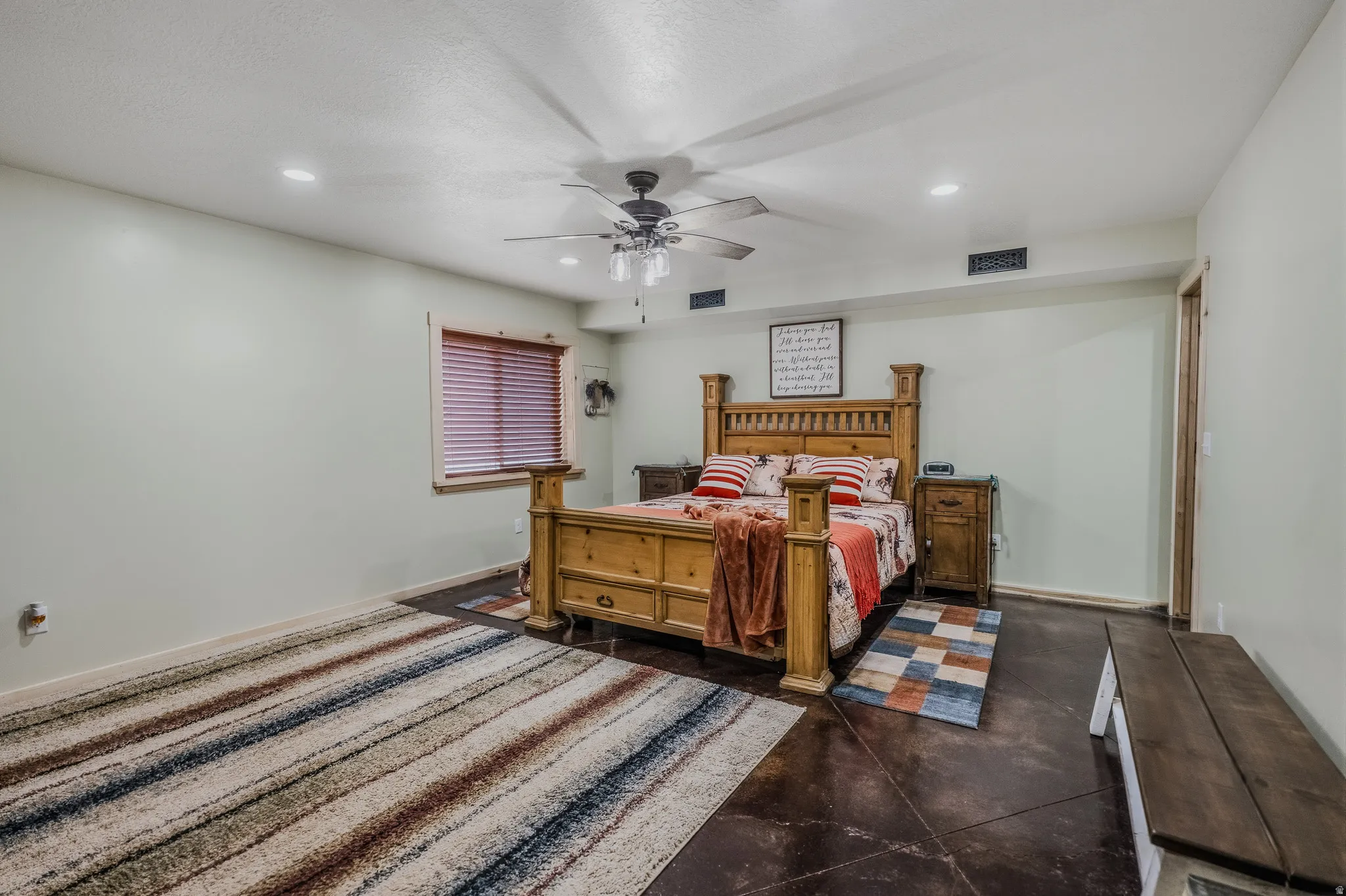 Recessed ceiling lighting, ceiling fan, window with wood blinds, and wood-trim door frame