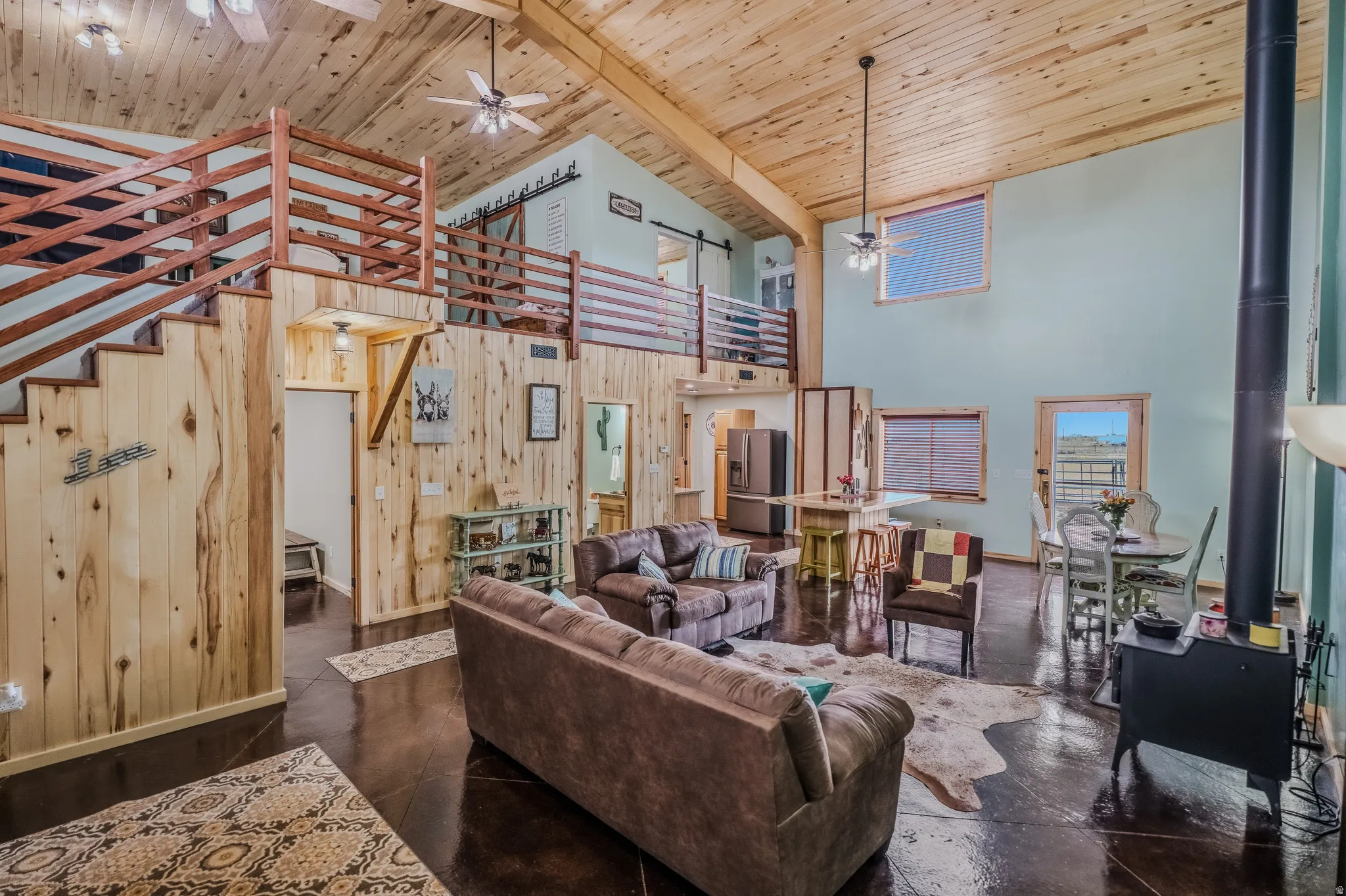 Vaulted wood-finish ceiling, exposed wood beams, and a wood-burning stove