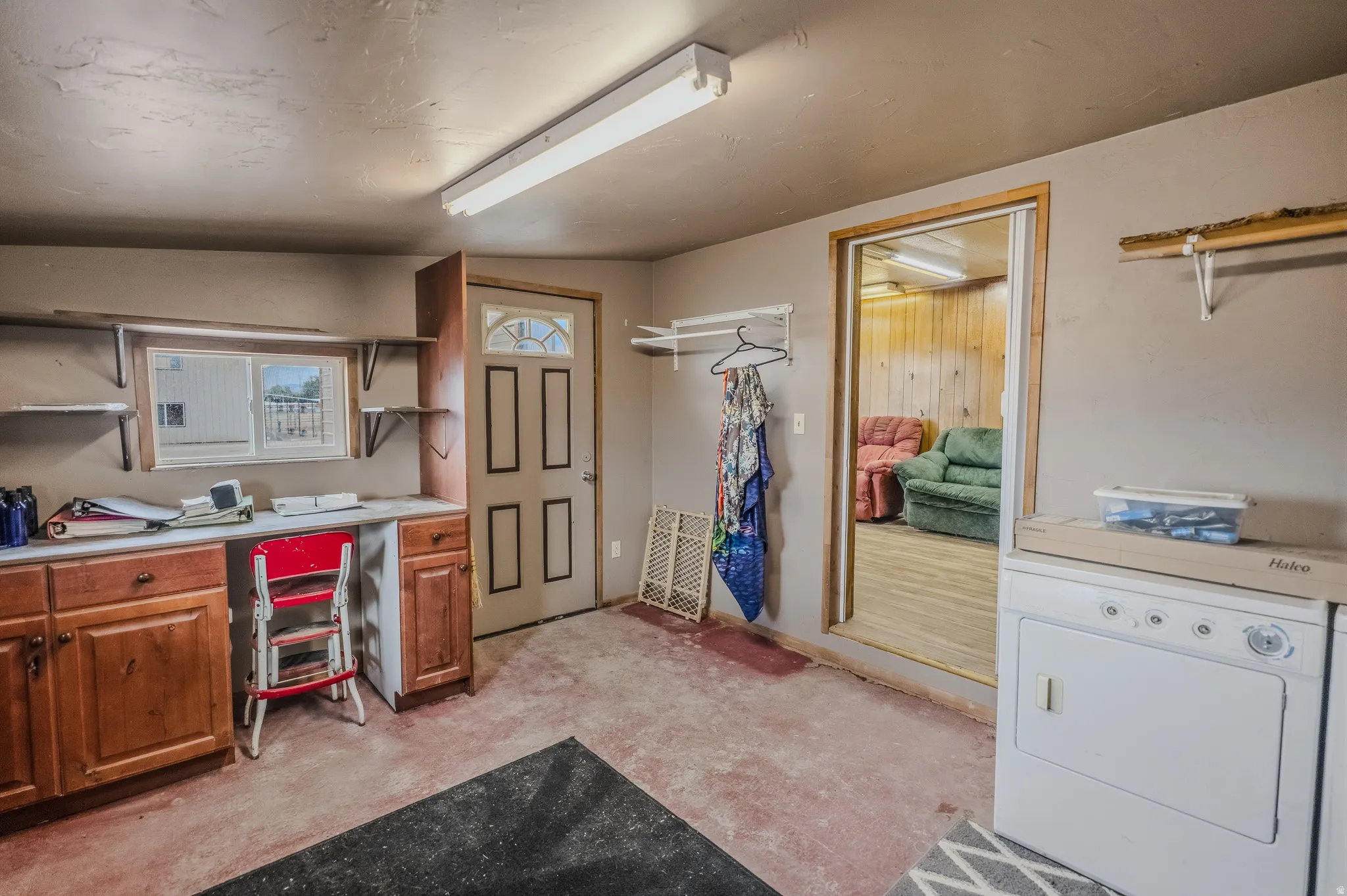 Built-in cabinetry with a countertop workspace, wall-mounted shelving, and a paneled entry door