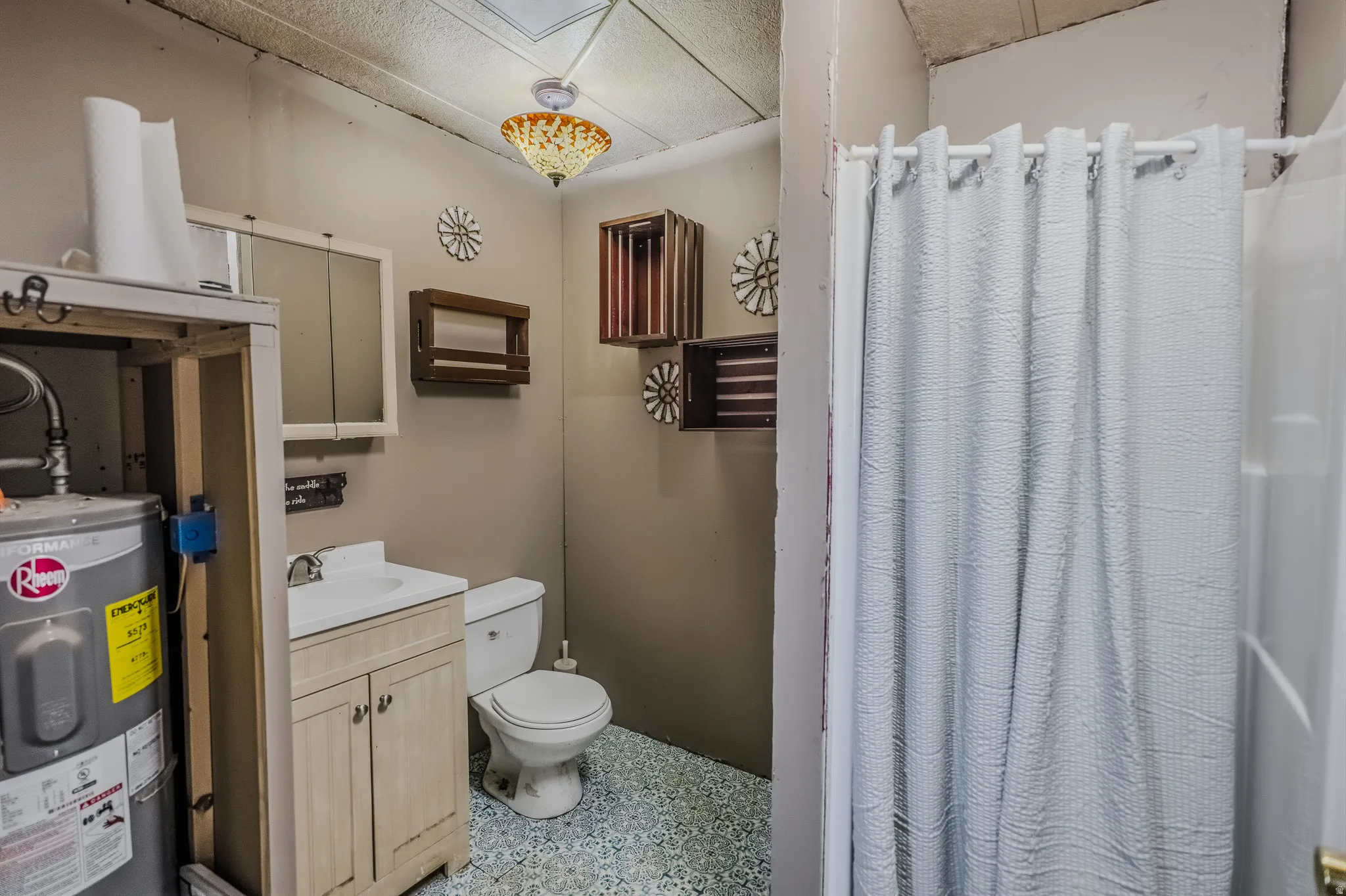 Bathroom featuring a single vanity, undermount sink, and light-toned cabinetry