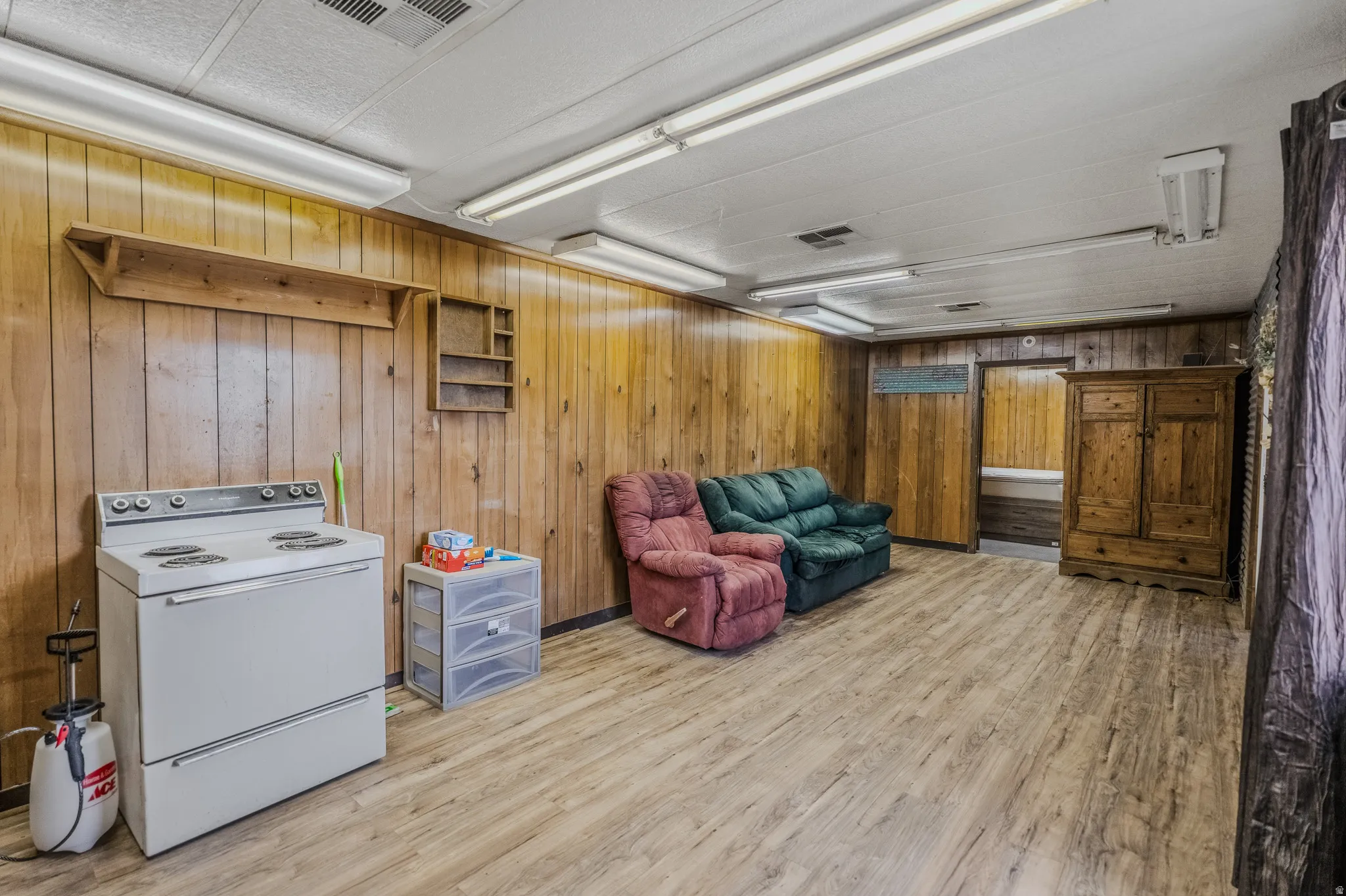 Wood-finish flooring, wood paneling, and overhead fluorescent lighting