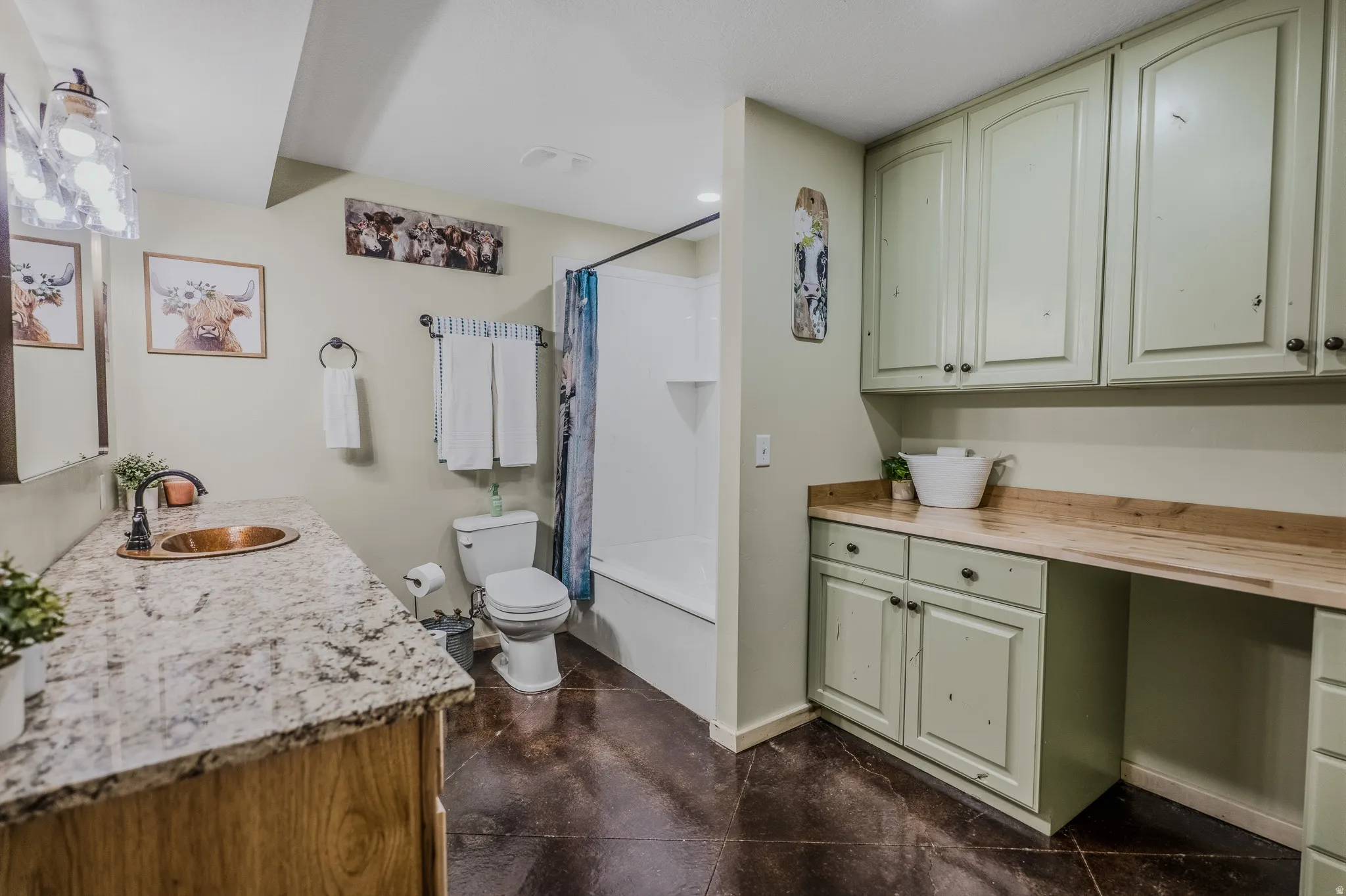 Full bathroom featuring a vanity with a copper basin and granite-style countertop, a toilet, and a combined tub and shower