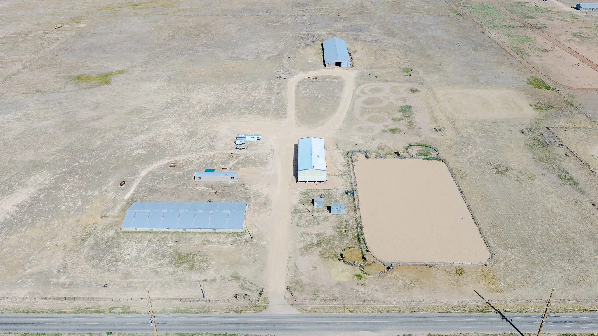 Expansive acreage featuring multiple outbuildings, an established track, a large arena, and a road frontage