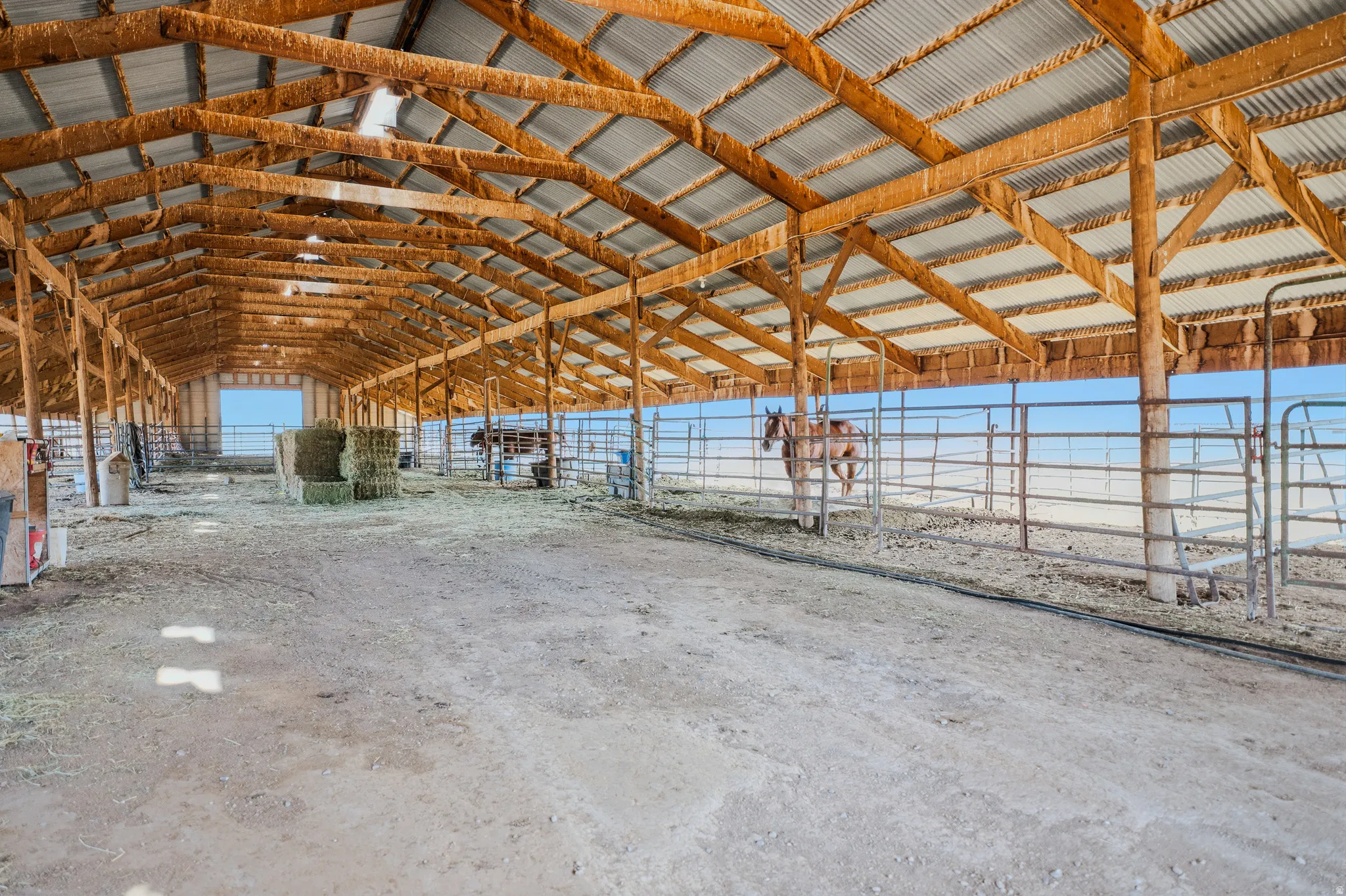 Expansive barn structure featuring a corrugated metal roof and exposed wood framing