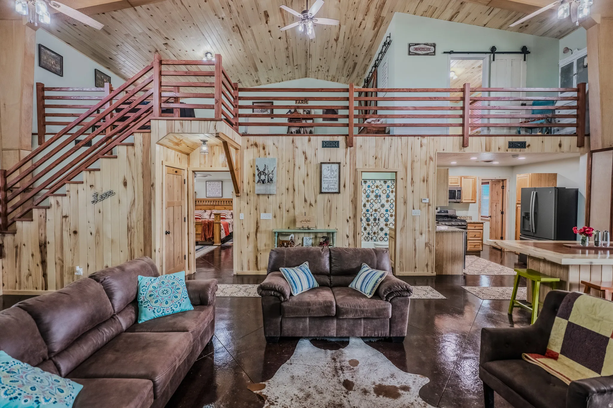 Vaulted wood-finish ceilings, wood-finish walls, wood-finish flooring, and a wood-finish staircase with railing