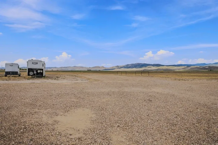 Expansive gravel lot with distant mountains