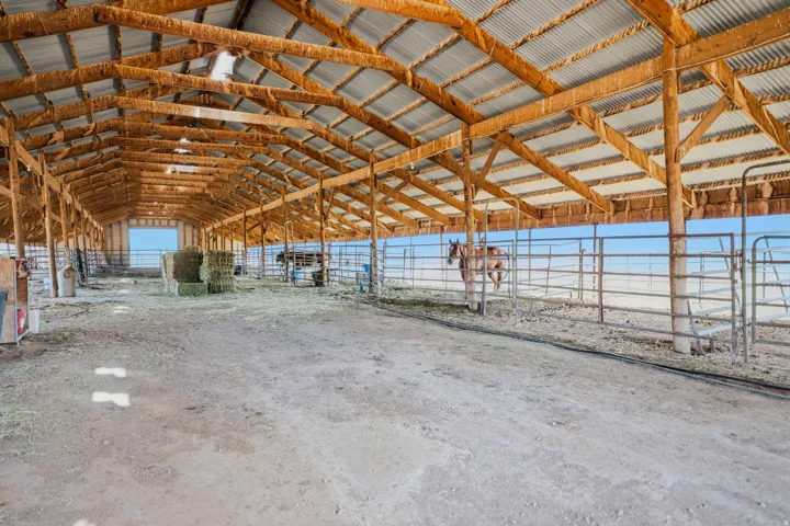 Expansive barn structure featuring a corrugated metal roof and exposed wood framing