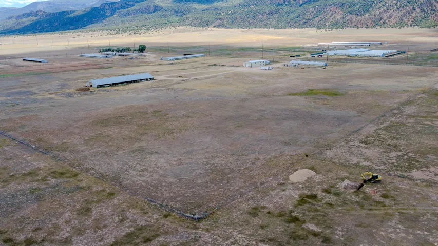 Expansive property featuring several large industrial structures and a mountainous backdrop