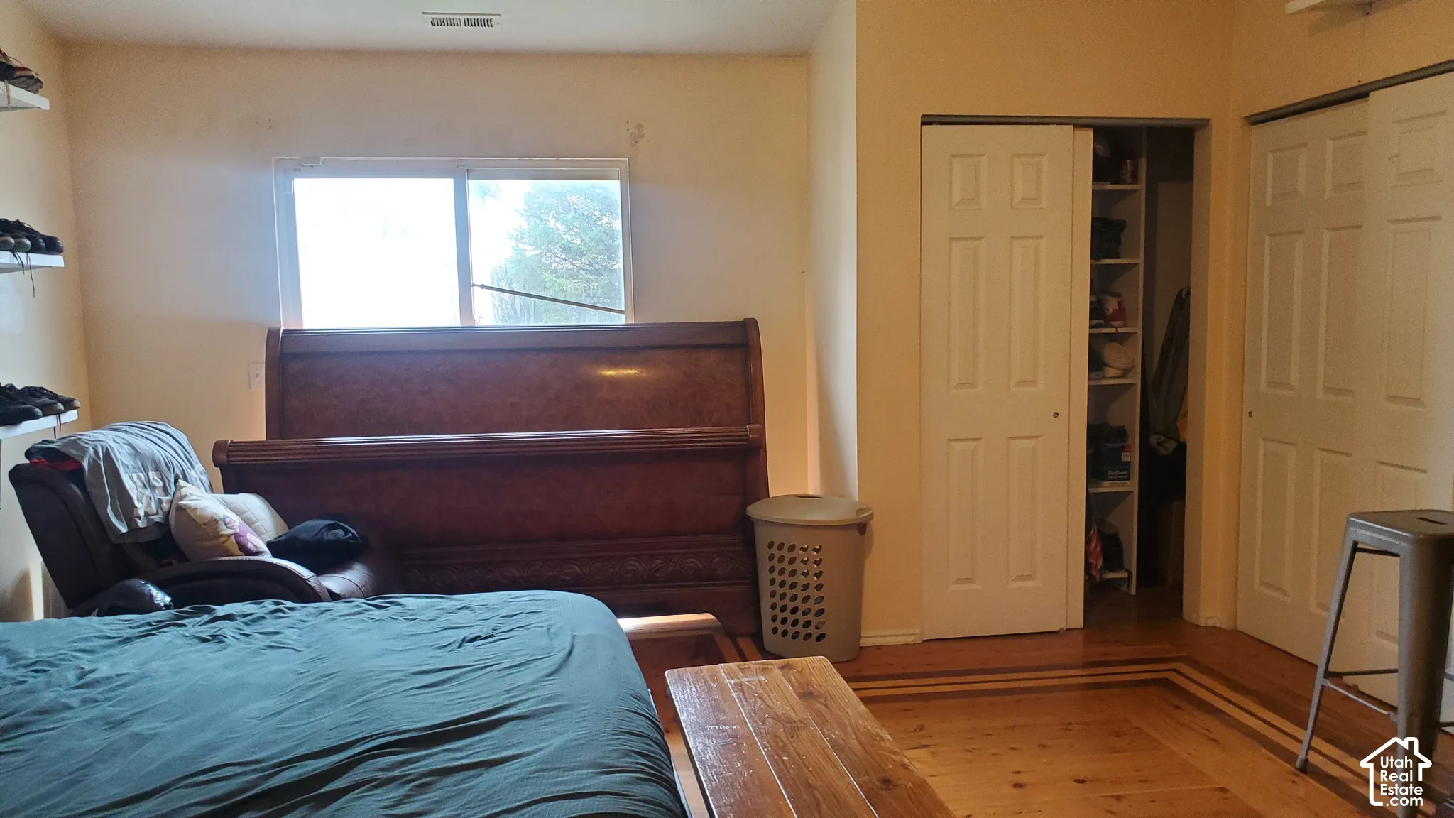 Wood-finish flooring with accent border, natural light from a window, and two closets with bi-fold doors