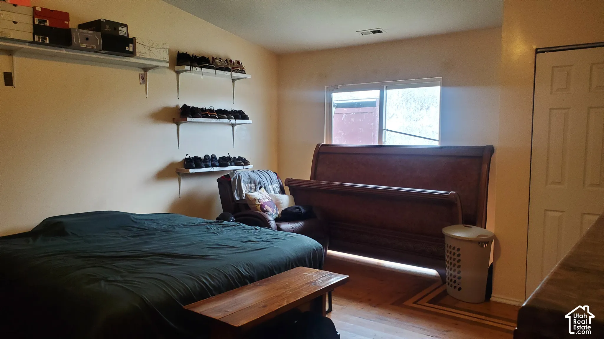 Wood-finish flooring with decorative inlay, built-in shelving, and a panel door