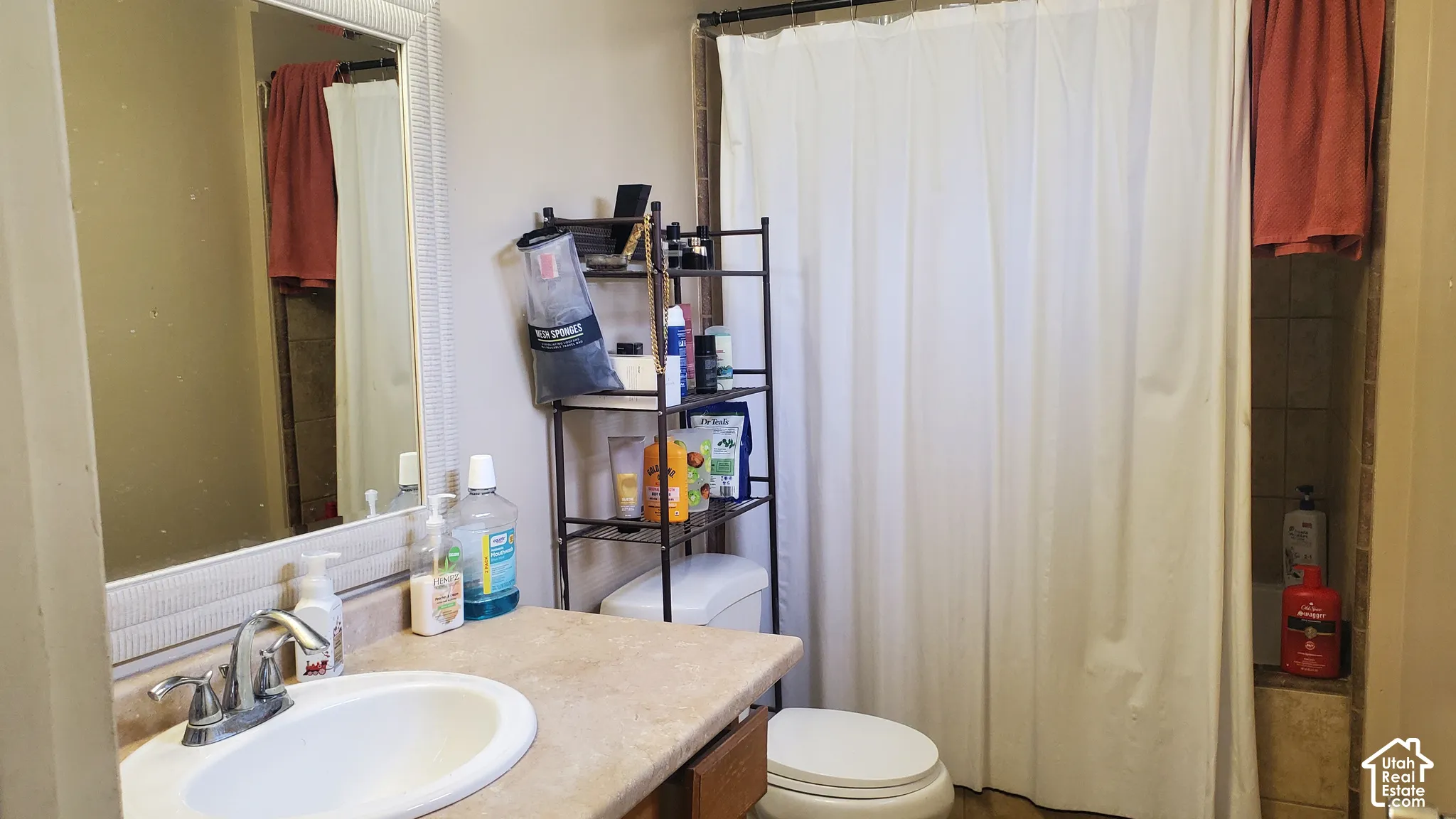 Vanity with integrated sink, chrome faucet, and framed mirror