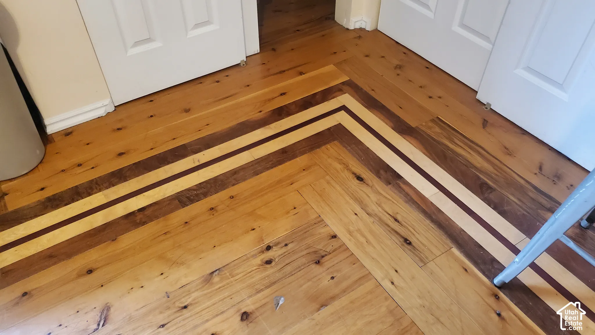 Hardwood flooring featuring a herringbone pattern with accent strips