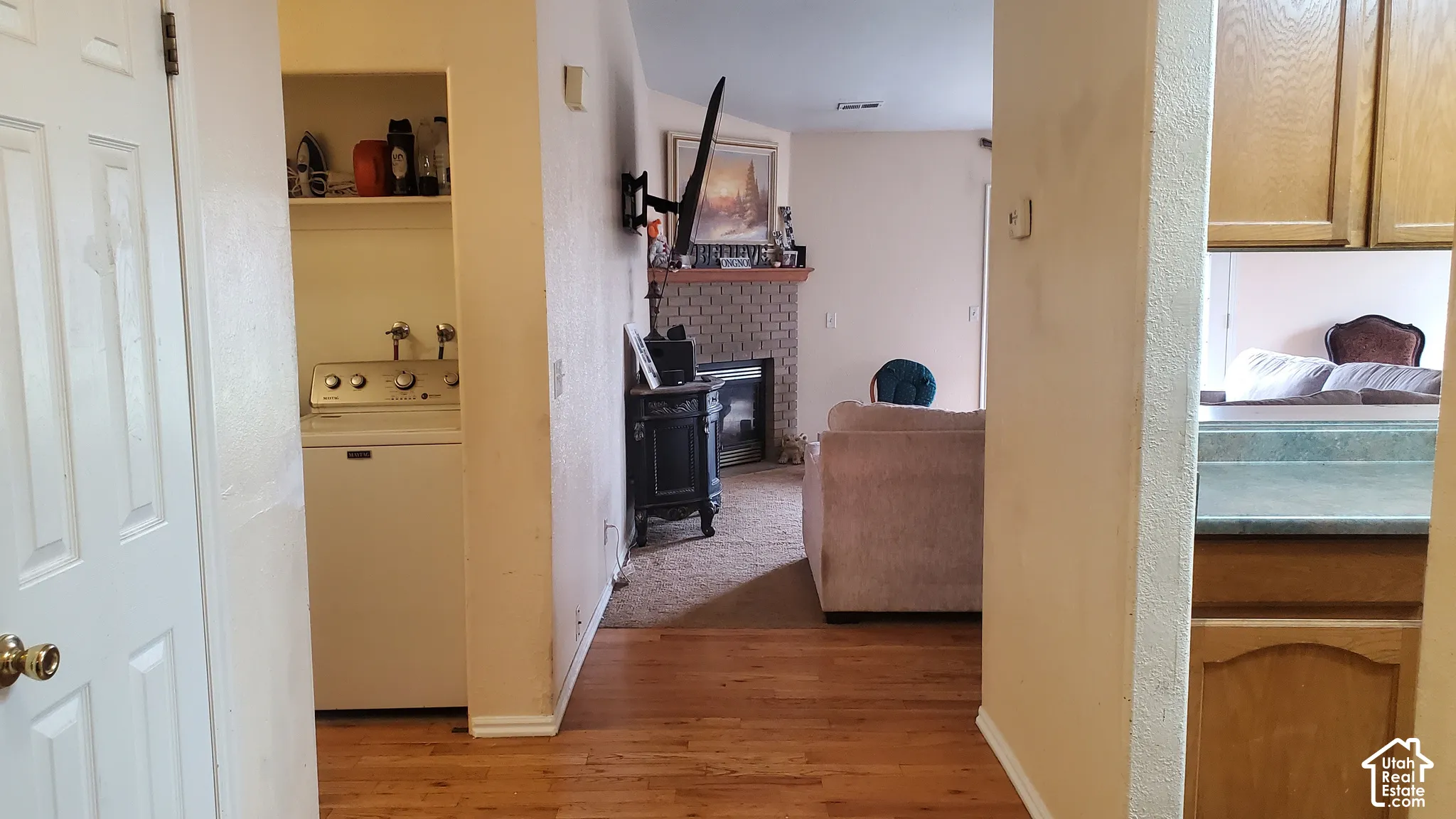 Hardwood-finish flooring, built-in shelving, and a tiled fireplace surround