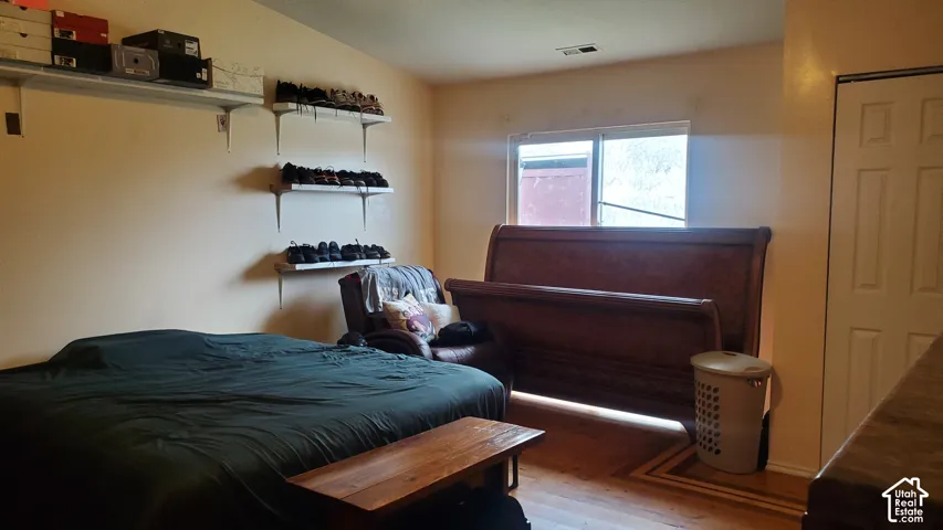 Wood-finish flooring with decorative inlay, built-in shelving, and a panel door