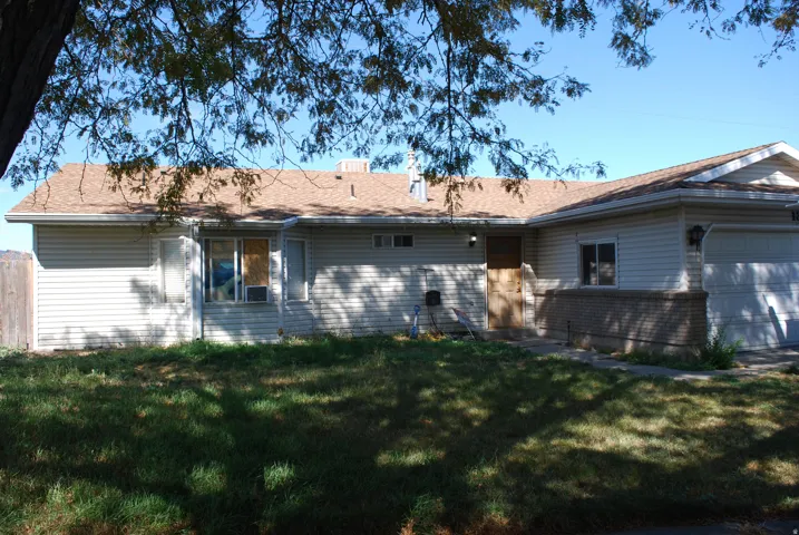 Siding exterior with multiple windows, an attached garage, and a partial brick facade